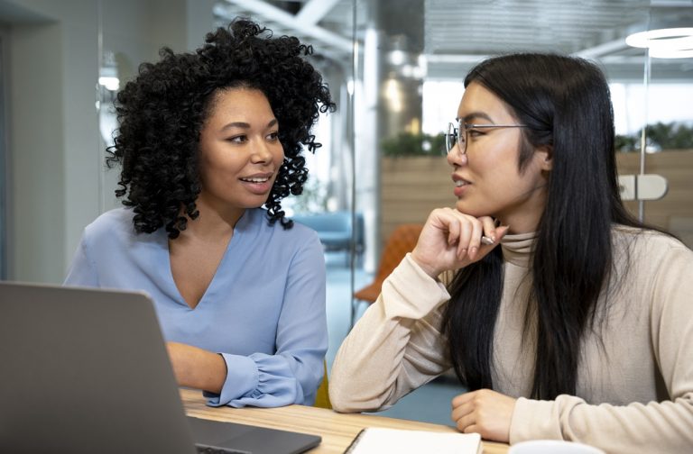 mulheres conversando em frente ao computador